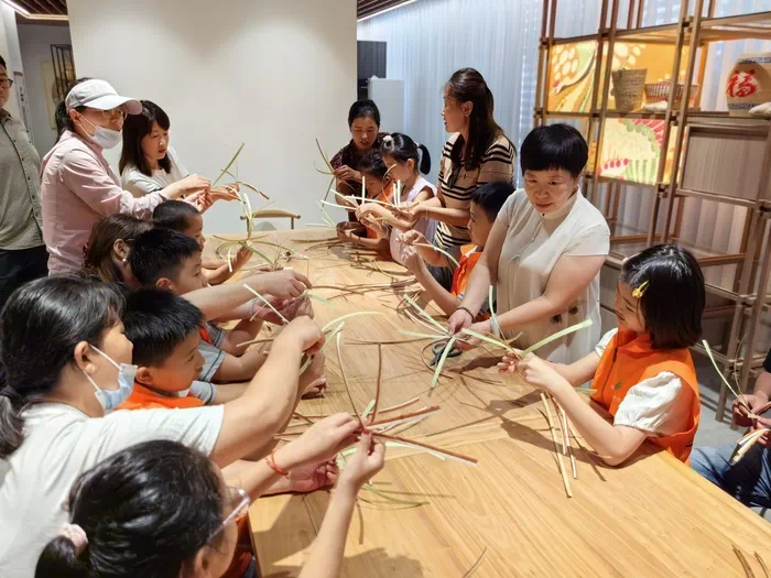 山東手造展示體驗(yàn)中心，博興草編傳承人張慧華帶孩子們體驗(yàn)草編技藝